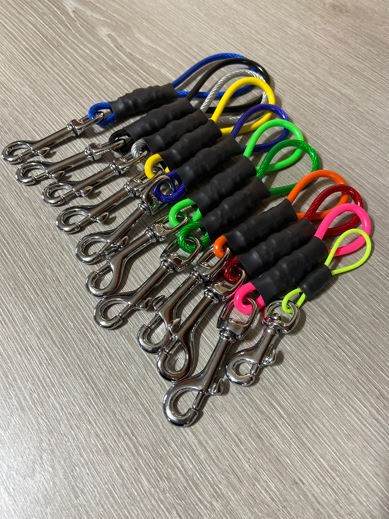 Set of keychains with colorful leashes on a wooden surface