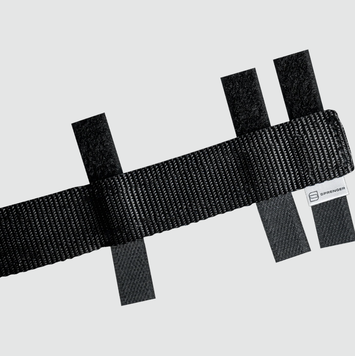 Black webbing strap with a brand label on a light gray background