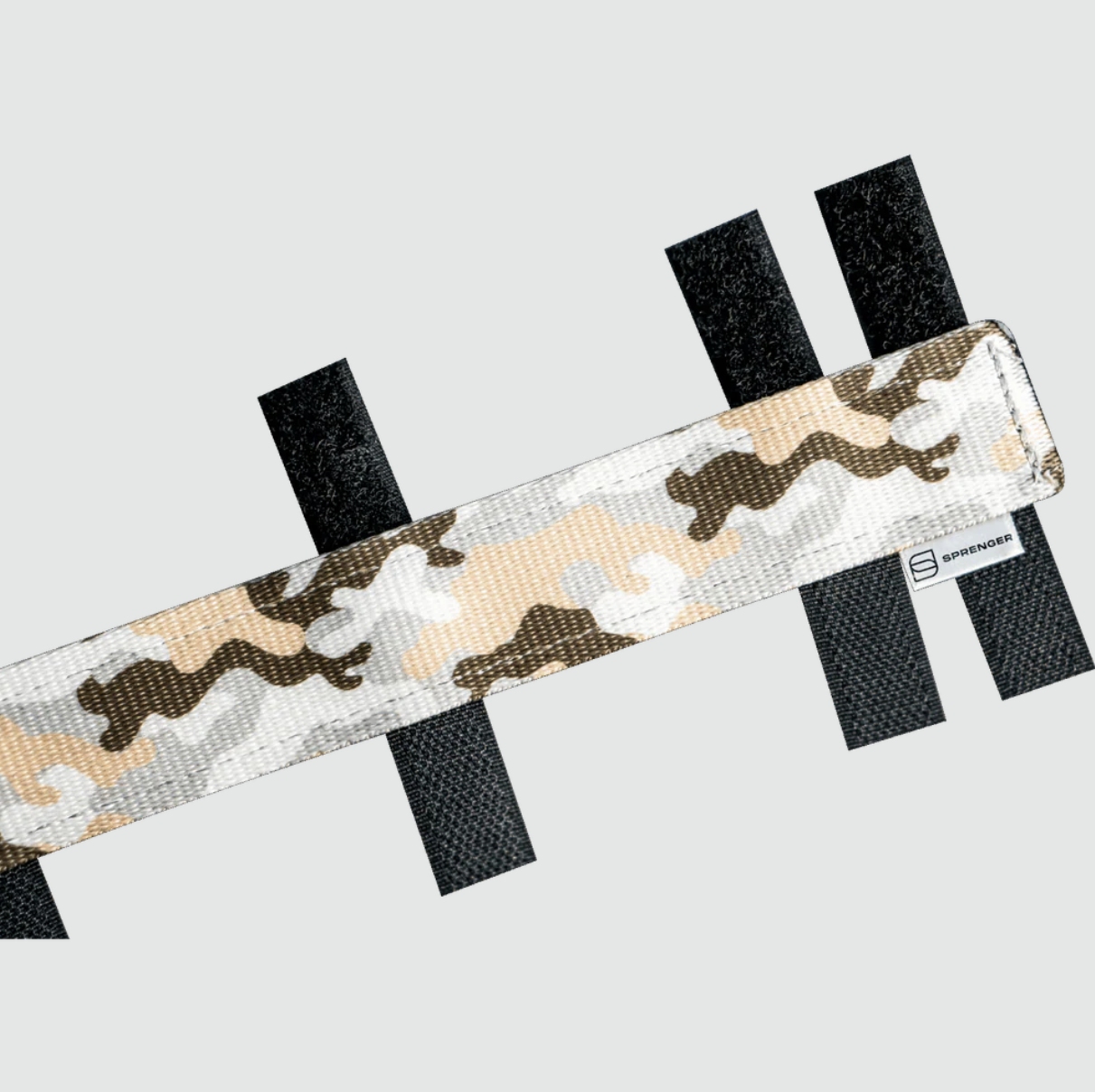 Camouflage-patterned strap with black fasteners on a light gray background