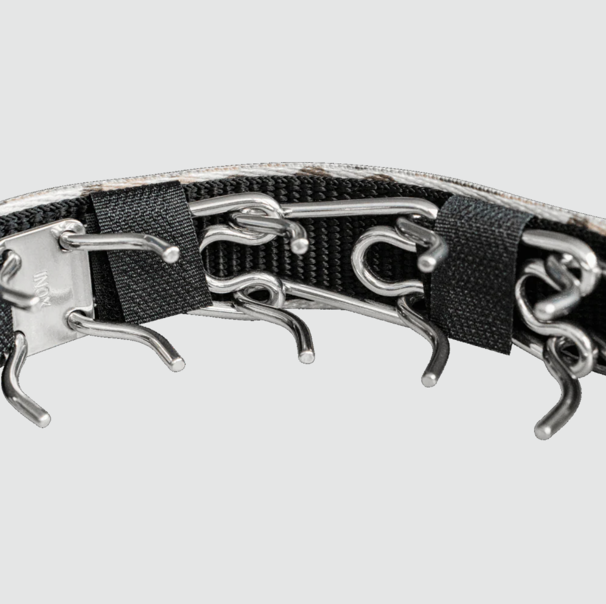 Close-up of a black dog collar with silver metal clasps on a light gray background